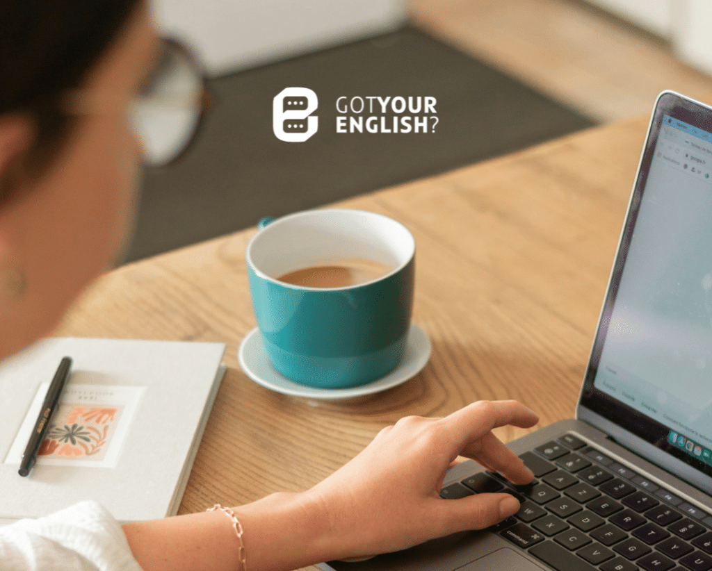 girl reading an English blog on laptop and drinking coffee